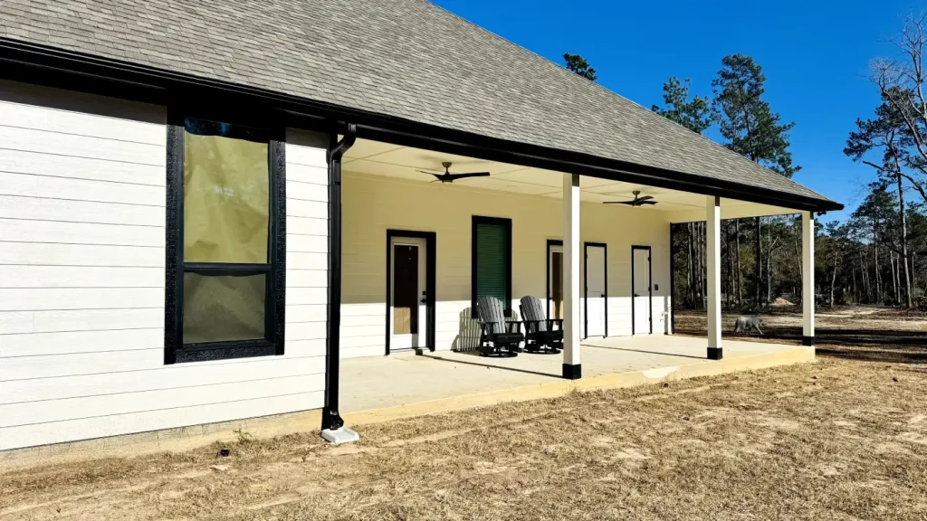 A residential house features clean black gutter systems installed along the roofline to keep pests out of gutters.