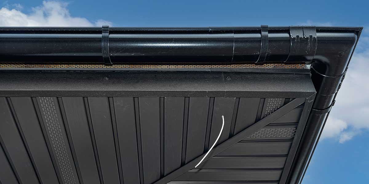 Black roof gutters and soffit exposed to humid air, illustrating how Gulf Coast moisture leads to gradual metal deterioration.